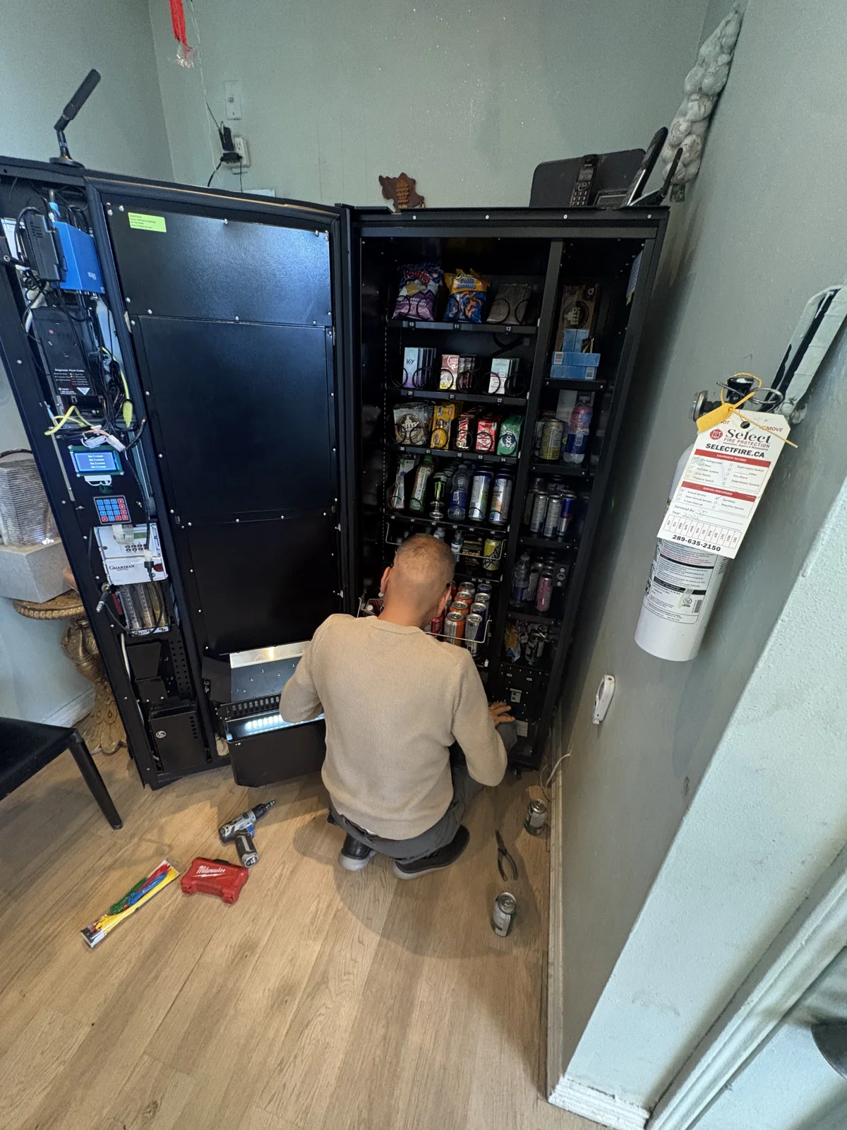 Hands-on maintenance inside an open vending machine